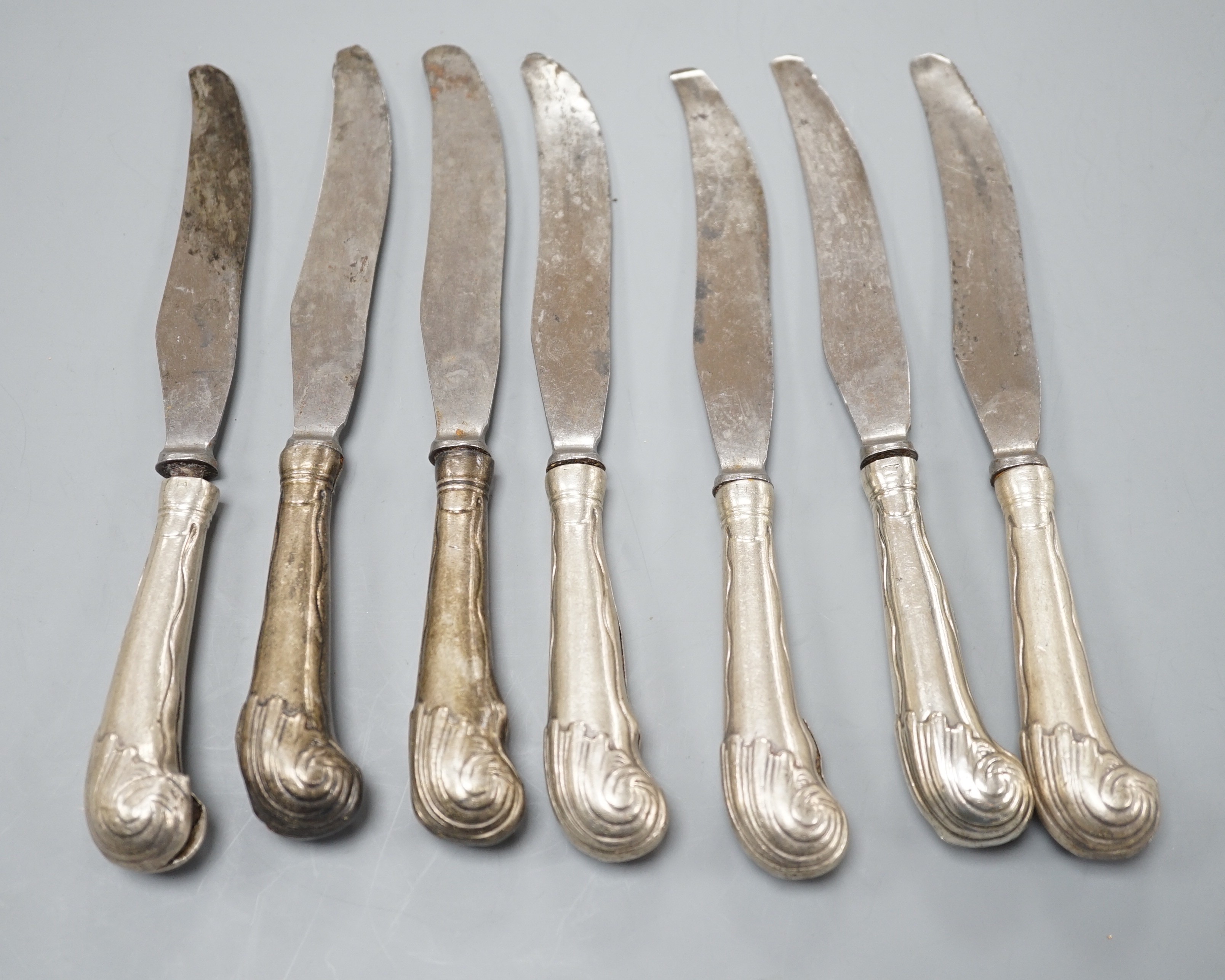 A set of seven William IV silver pistol handled dessert knives, Sheffield, 1836, engraved with the Butler family crest, three with splits to the grips.